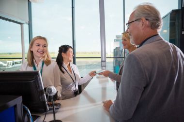 Yolcu havaalanında kontuarında bakarak personel