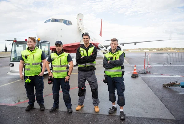 Ground Team With Arms Crossed Standing Against Airplane — Stock Photo, Image