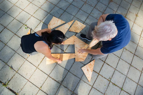 Directly Above Shot Of Friends Solving Wooden Planks Puzzle — Stock Photo, Image