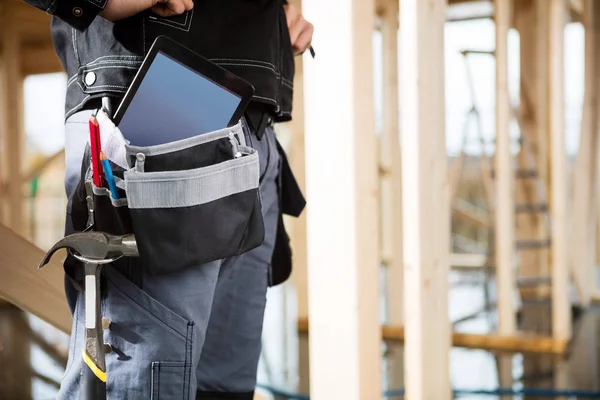 Giovane falegname con computer tablet e strumenti in borsa in loco — Foto Stock