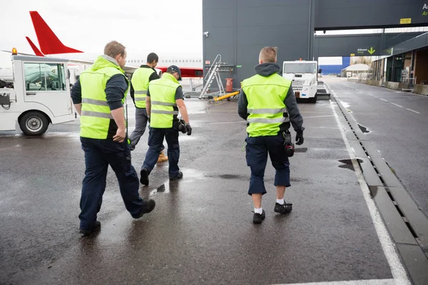 Rear View Of Male Workers Walking On Wet Runway — Stock Photo, Image