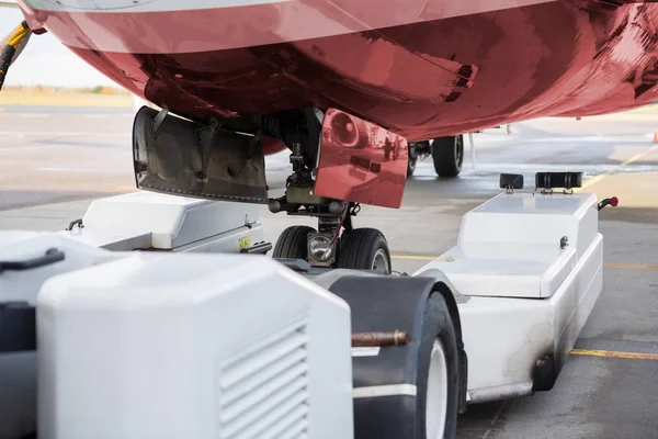 Máquina de reboque e avião na pista — Fotografia de Stock