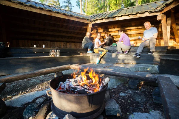 Burning Firepit con amigos preparando comida en cobertizo — Foto de Stock