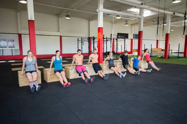 Clientes realizando caídas de tríceps en el gimnasio — Foto de Stock