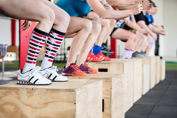 Низкий раздел женщин, выступающих Box Jumps с друзьями — стоковое фото