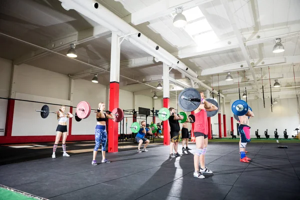 Masculino e feminino amigos levantamento barbells — Fotografia de Stock