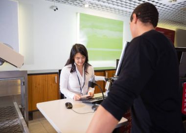 Havaalanı Check-in sırasında yolcu pasaport inceleyerek personel