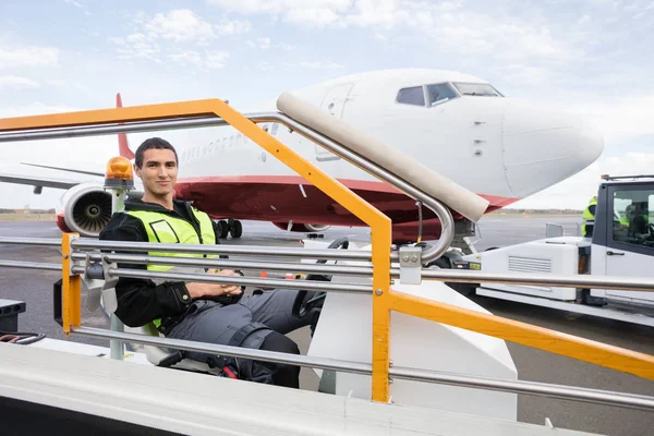 Bagaj taşıyıcı kamyon üzerinde oturan erkek işçi