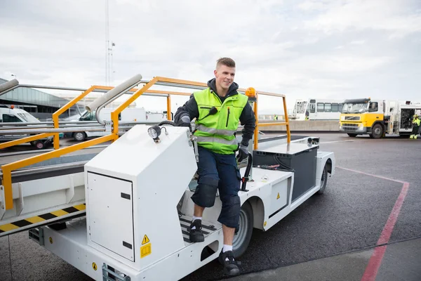 Operaio sbarco bagagli trasportatore camion sulla pista dell'aeroporto — Foto Stock