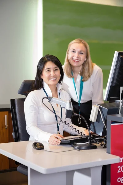 Personal femenino sonriente en el mostrador de facturación del aeropuerto — Foto de Stock