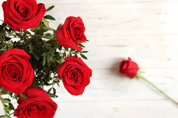 Bouquet de roses rouges sur une table en bois — Photo