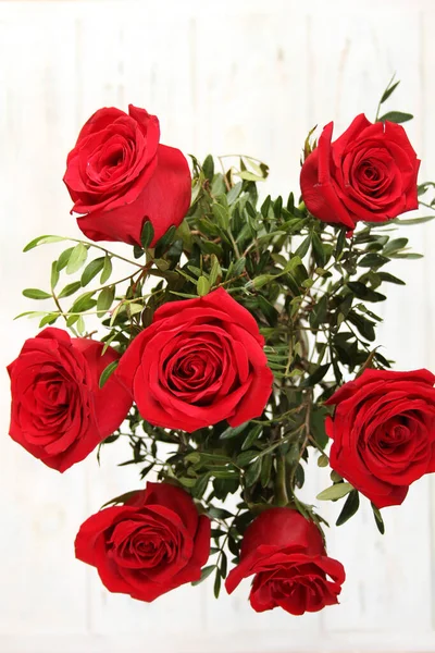 红玫瑰花束在一张木制桌子上 — 图库照片