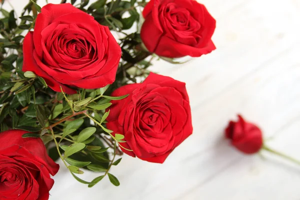 Bouquet de roses rouges sur une table en bois — Photo