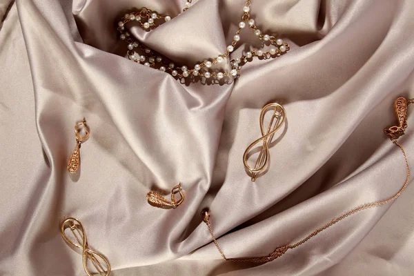 灰色丝绸上的金色珠宝 — 图库照片