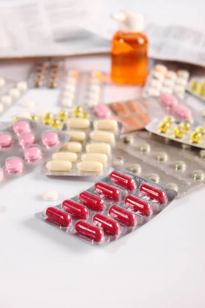 Många olika piller på ett vitt bord — Stockfoto