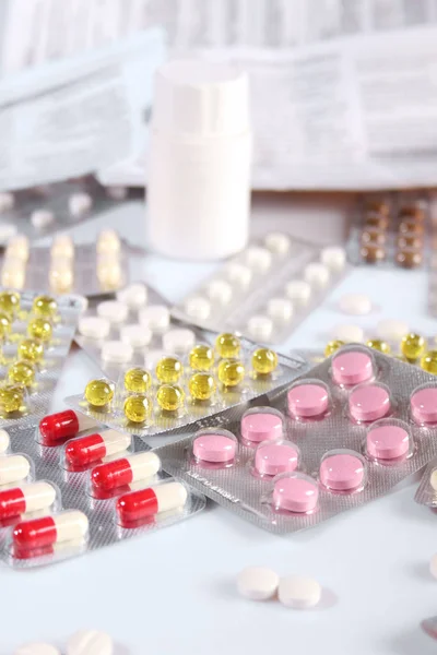 Molte pillole diverse su un tavolo bianco — Foto Stock