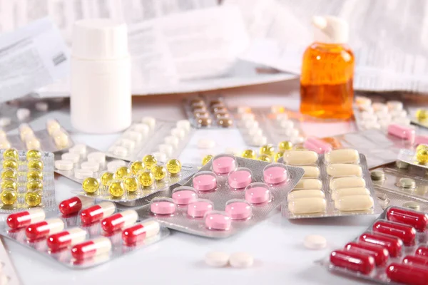 Beaucoup de pilules différentes sur une table blanche — Photo