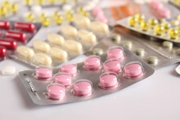 Viele verschiedene Pillen auf einem weißen Tisch — Stockfoto