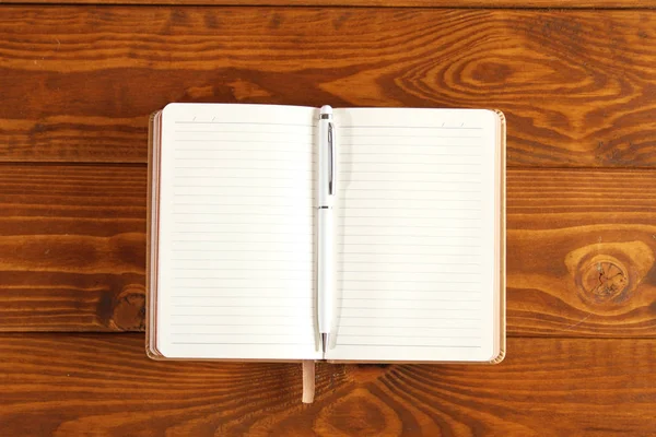 Caderno marrom em uma mesa de madeira — Fotografia de Stock