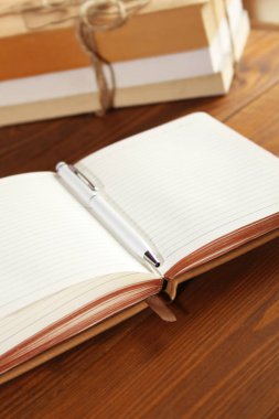 Tahta bir masanın üzerinde kahverengi defter.