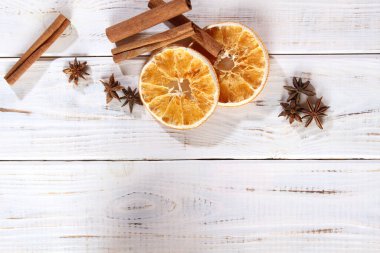 Ahşap bir masada baharatlar. Kurutulmuş portakal, karanfil ve tarçın..