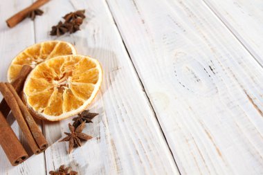 Ahşap bir masada baharatlar. Kurutulmuş portakal, karanfil ve tarçın..