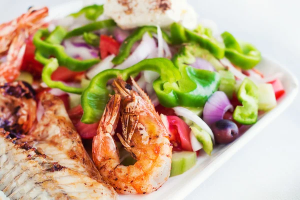 Grilled seafood with salad and feta cheese (selective focus) — Stock Photo, Image