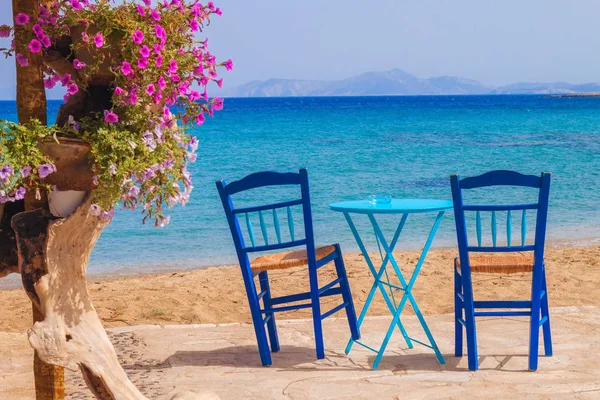 Restaurace stůl a židle s relaxační pohled na pláž Moutsouna, ostrov Naxos, Řecko — Stock fotografie