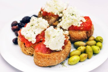 Girit meze - dakos, rusk ile domates sosu, zeytin ve yerel staka peynir (seçici odak)