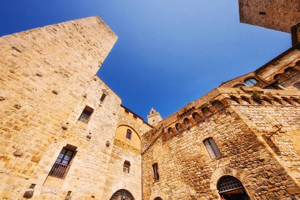 A wide angle shot of the medieval architecture in the Piazza della Cisterna square of San Gimignano, Italy — Stock Photo, Image