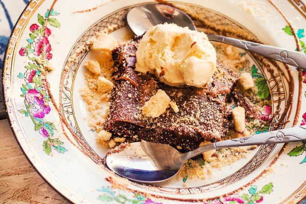 Bolinho de chocolate com sorvete servido com duas colheres em um prato tradicional rústico — Fotografia de Stock