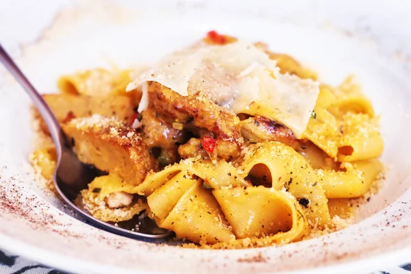 Pasta dish with cured pork, parmesan cheese and grilled mushrooms, selective focus — Stock Photo, Image