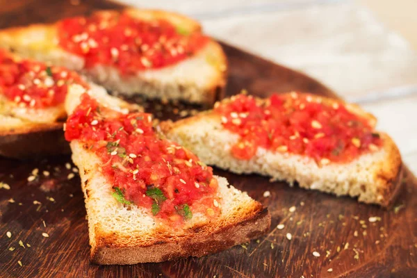 Klasický rajče bruschetta podávané na dřevěném prkénku, Selektivní ostření — Stock fotografie