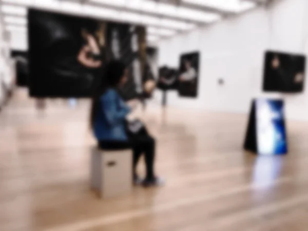 Gente en la galería de arte con efecto borroso en la foto . —  Fotos de Stock