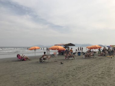 Güneşli bir günde Santos plajı. Santos sahilindeki turistler tatilde ve gün batımında dinleniyorlar. Brezilya 'nın Sao Paulo eyaletindeki Santos şehri..