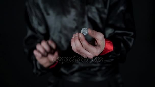 동전은 마술사 손과 그의 손에서 나오는 연기에서 사라집니다. — 비디오