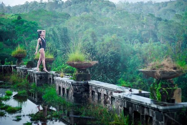 Chica en traje de baño en el hotel podrido abandonado místico en Bali con el cielo azul. Países Bajos — Foto de Stock