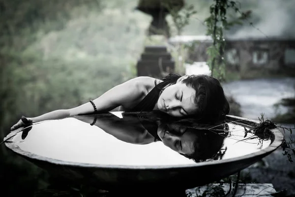 Chica con su reflejo en un tazón grande en el hotel místico abandonado en Bali. Países Bajos — Foto de Stock