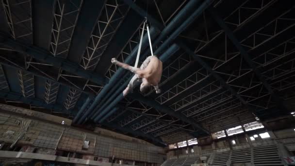 Artista de circo en las correas aéreas en el gran edificio desierto — Vídeos de Stock
