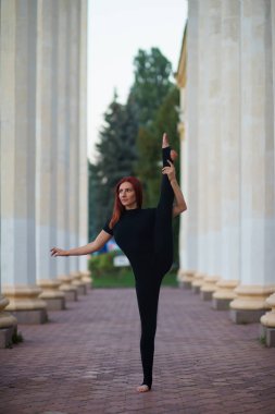 Kırmızı saç kızla tutmak beyaz sütunlar arasında bir bölünme