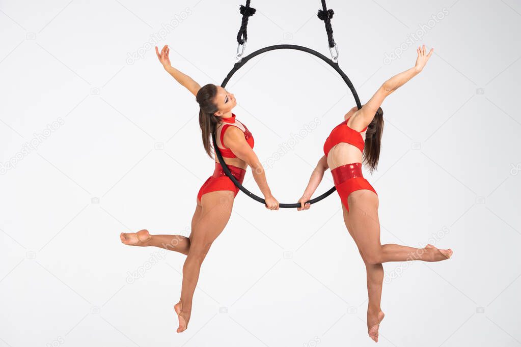 Twins female circus duo on the Aerial hoop isolated on white