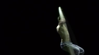 Cyr Wheel 'deki kaslı sirk sanatçısı ağır çekimde zor numaralar yapıyor. Konsantrasyon ve denge kavramı