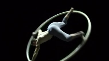 Cyr Wheel 'deki kaslı sirk sanatçısı ağır çekimde zor numaralar yapıyor. Konsantrasyon ve denge kavramı