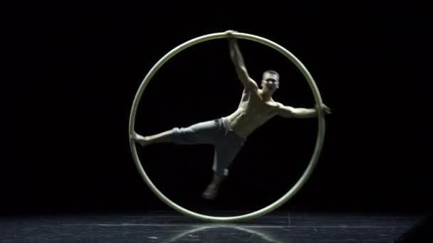 Cyr Wheel 'deki kaslı sirk sanatçısı ağır çekimde zor numaralar yapıyor. Konsantrasyon ve denge kavramı — Stok video