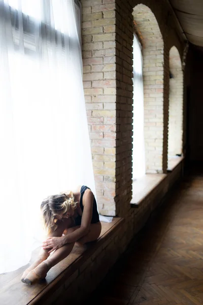 Bela bailarina no fato de banho preto posando na grande janela no salão de luz. Conceito de estilo de vida saudável — Fotografia de Stock