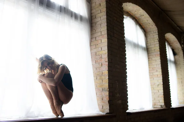 Bela bailarina no fato de banho preto posando na grande janela no salão de luz. Conceito de estilo de vida saudável — Fotografia de Stock