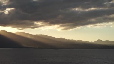 Dramatik bir gün batımı. Denizde dağların üzerinde güzel ışınlar. Guadeloupe Adası
