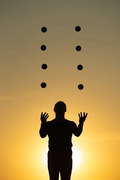 Silhouette de jongleur avec boules sur coucher de soleil coloré — Photo