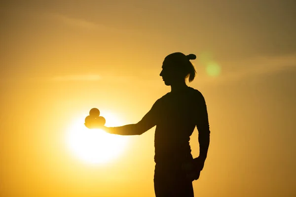 Silhouette de jongleur avec boules sur coucher de soleil coloré — Photo