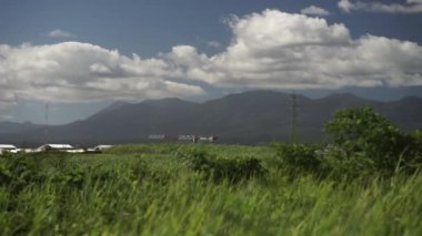 Guadeloupe 'daki yeşil dağ manzarası. Yeşil çimenler yavaş çekimde ön planda, Karayipler' de Fransızca bölümü.